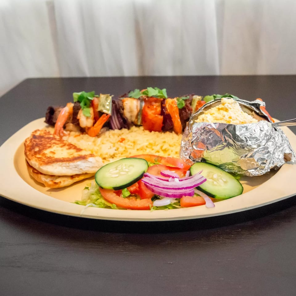 Ciros Sea & Mexican Food's shrimp and beef skewer with rice, baked potato, and salad.